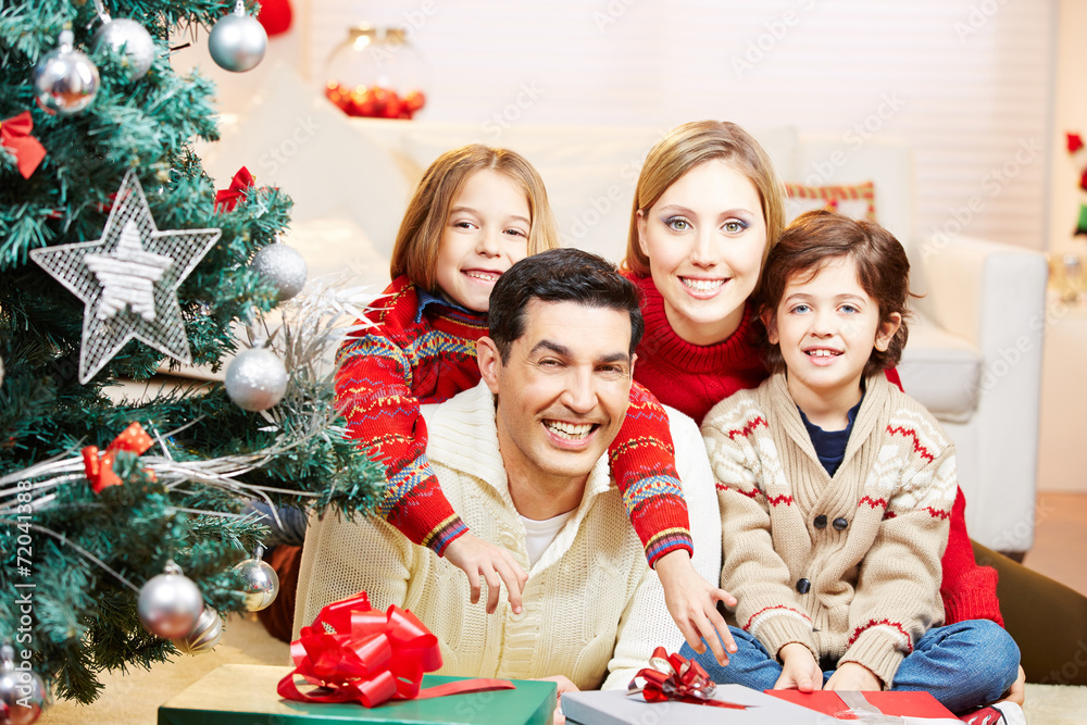 Familie zu Weihnachten mit Geschenken am Weihnachtsbaum Stock Photo