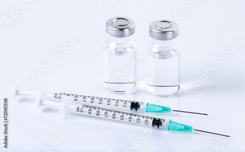 medical ampoules and syringe on white background