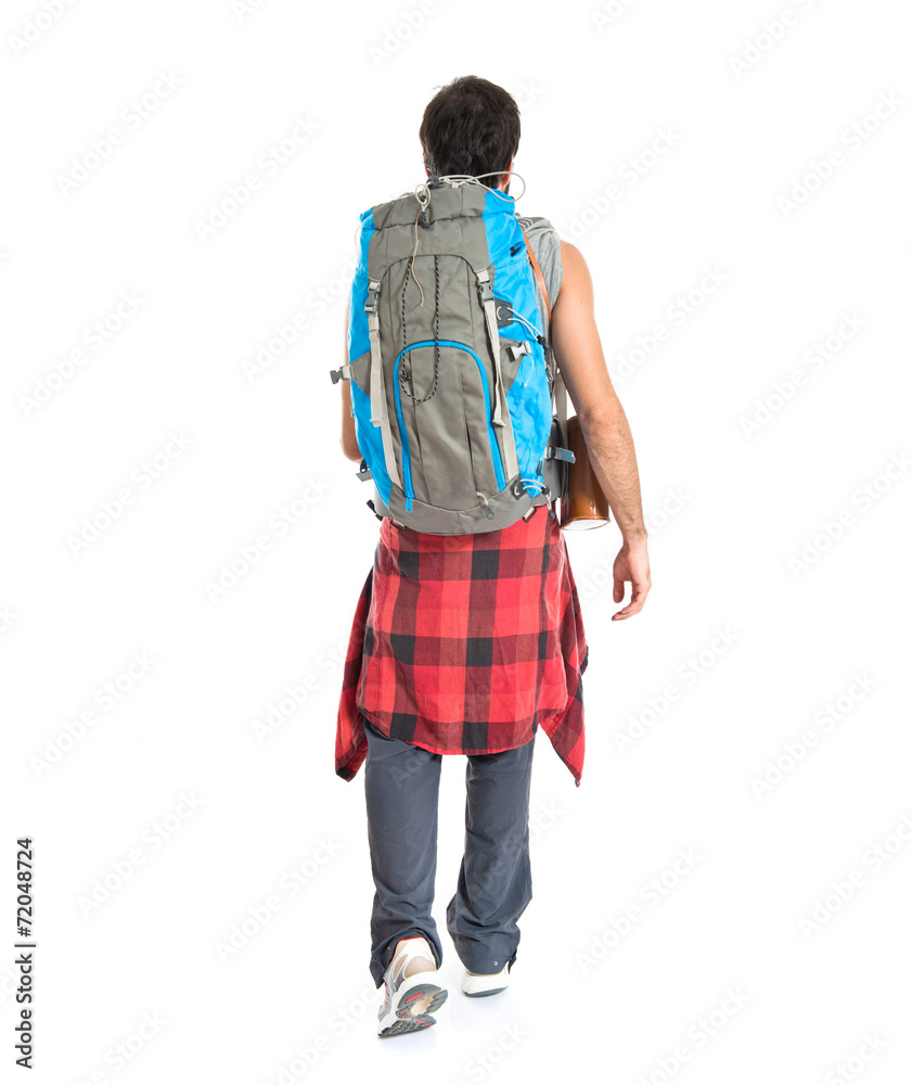 Young backpacker walking over white background Young backpacker walking over white background