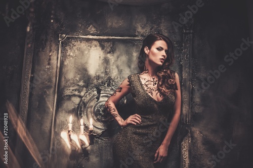 Tattooed beautiful woman in old spooky interior