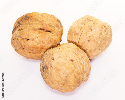 Three dried walnuts isolated on white background