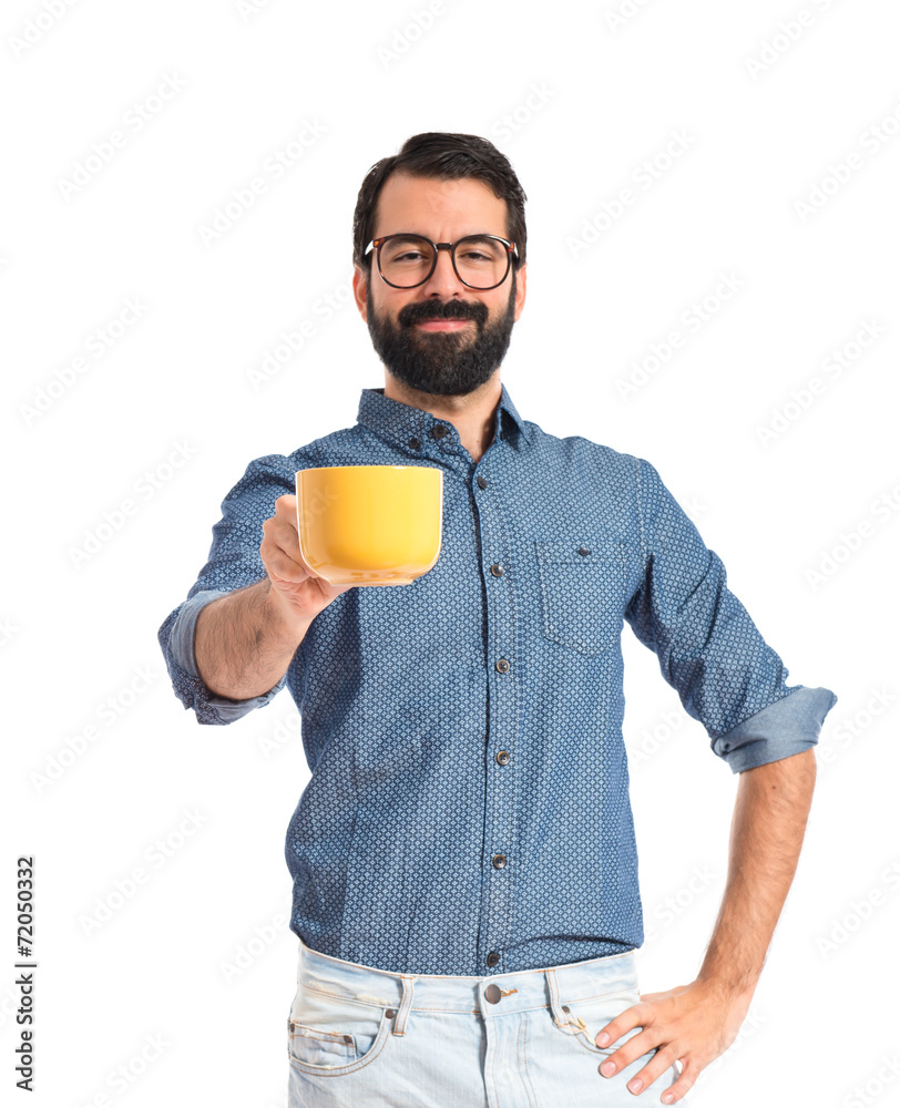 Young hipster man holding a cup of coffee Young hipster man holding a cup of coffee