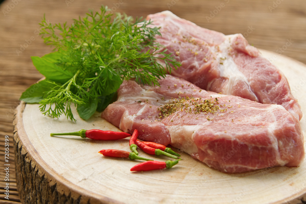 Raw pork on cutting board and vegetables