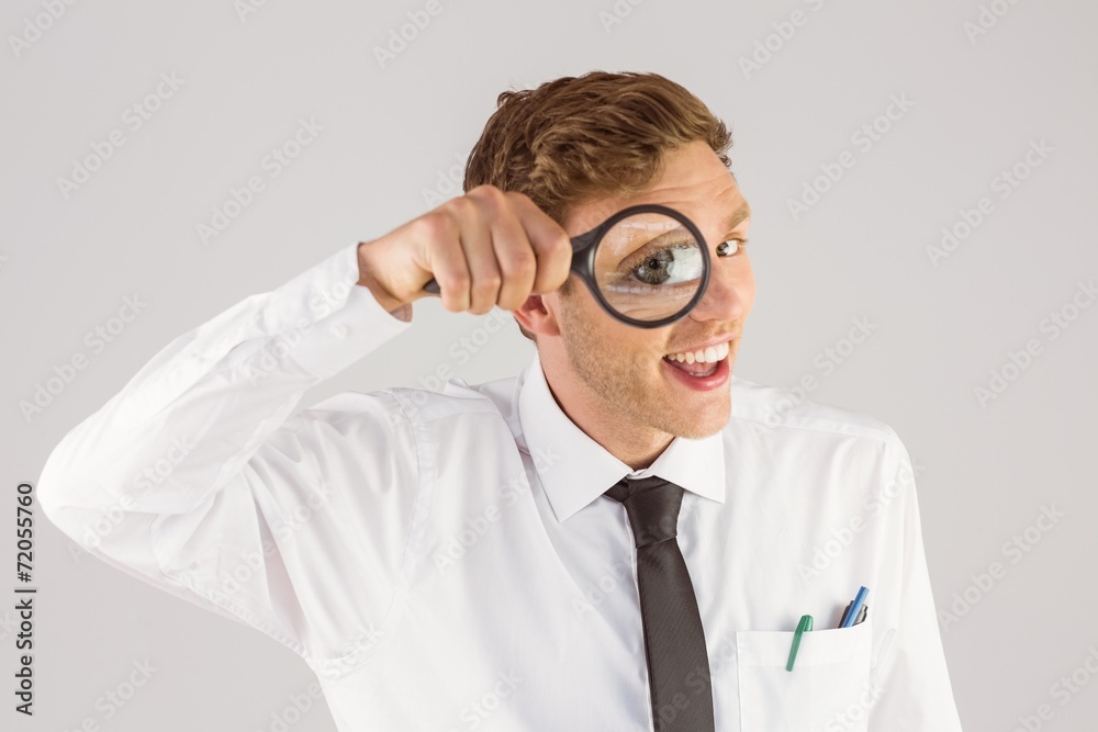 Geeky businessman looking through magnifying glass Geeky businessman looking through magnifying glass