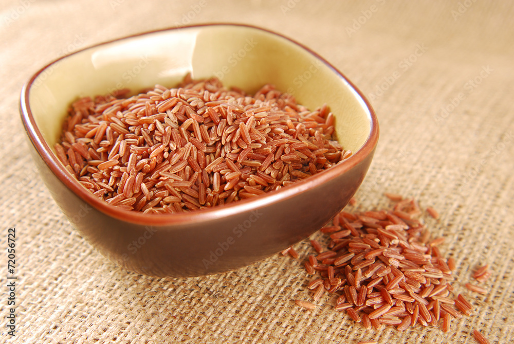 Fototapeta red rice in bowl on hessian fabric