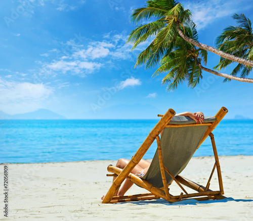 Tropical beach and woman relaxing sitting on the bamboo chair