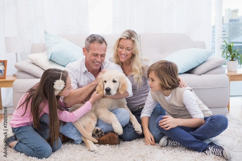 Smiling family with their pet yellow labrador on the rug Smiling family with their pet yellow labrador on the rug