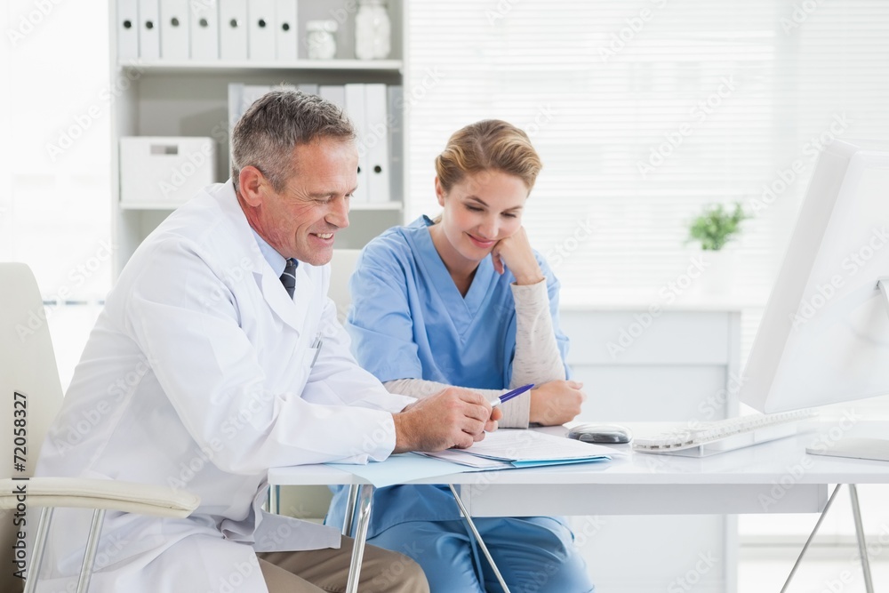 Doctor and nurse reading over medical notes Doctor and nurse reading over medical notes