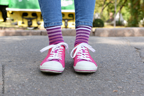 Fototapeta Naklejka Na Ścianę i Meble -  Female legs in colorful socks and sneakers outdoors