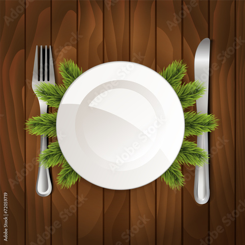 White plate with cutlery on wooden background