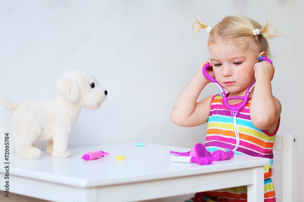 Little girl playing doctor with puppy toy Little girl playing doctor with puppy toy