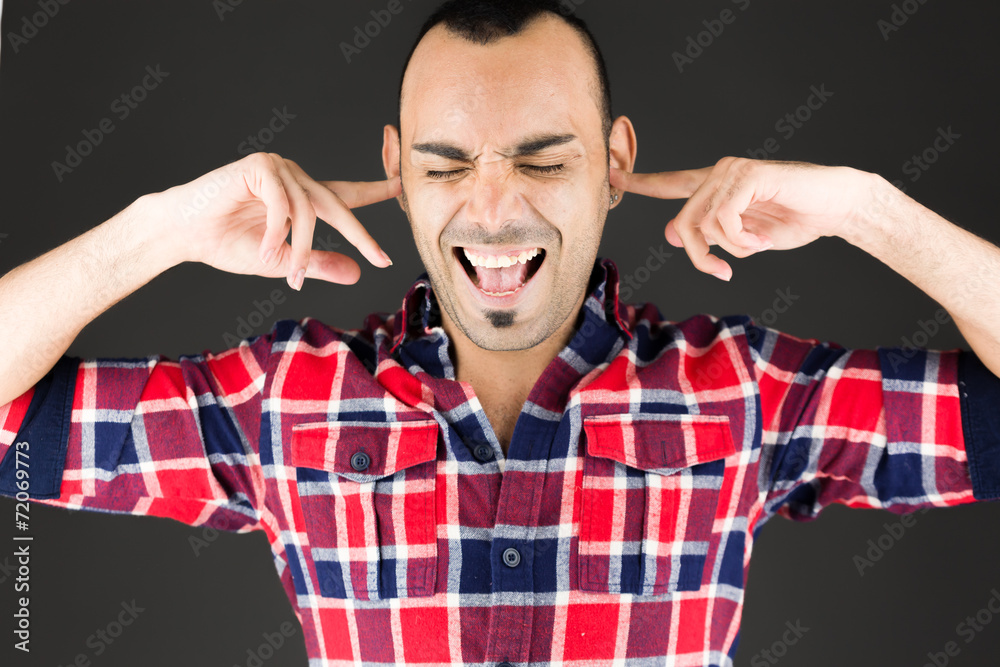 Naklejka premium model isolated on plain background plugging ears with fingers
