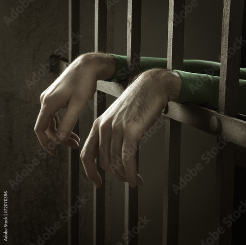 Man in jail hands close-up