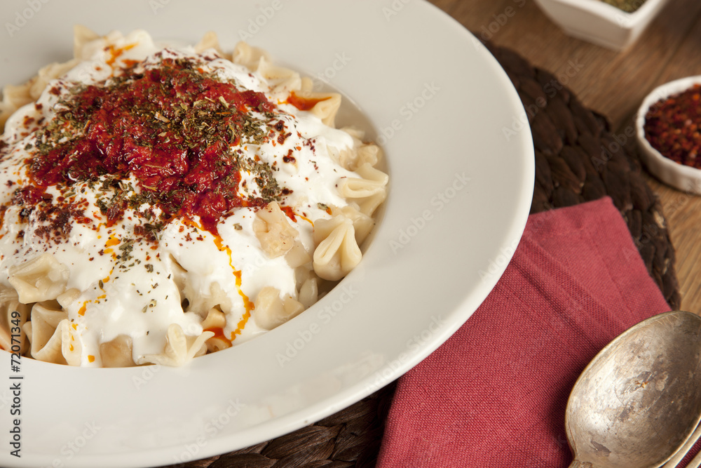 Turkish Manti manlama on plate with tomatoes sauce, yogurt Turkish Manti manlama on plate with tomatoes sauce, yogurt