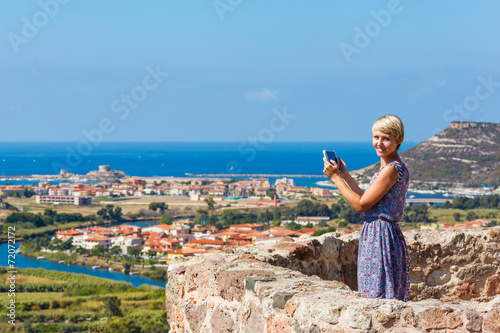 young girl tourist uses a tablet © miklyxa