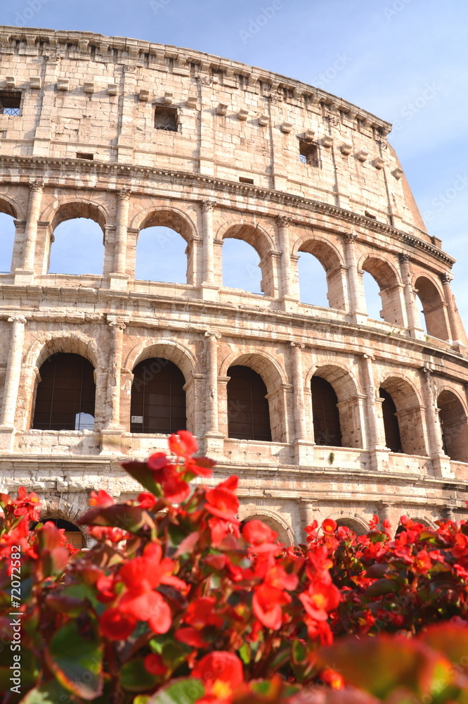 Monumentalne coloseum w Rzymie na tle niebieskiego nieba, Włochy - obrazy, fototapety, plakaty 