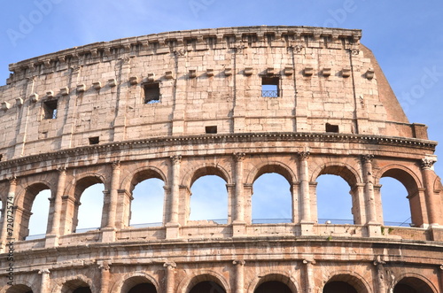 Monumentalne coloseum w Rzymie na tle niebieskiego nieba, Włochy #72072574