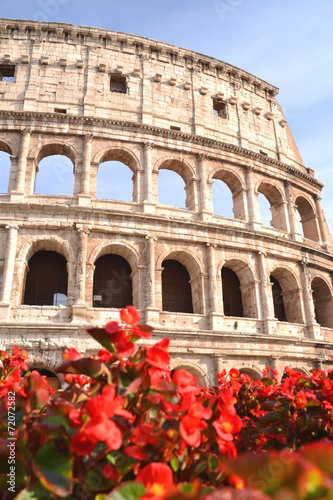 Monumentalne coloseum w Rzymie na tle niebieskiego nieba, Włochy #72072582