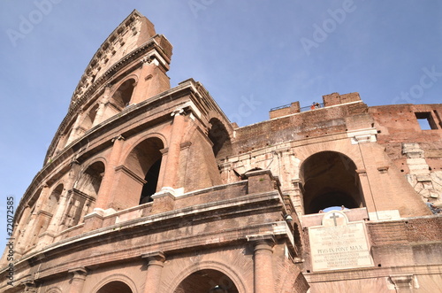 Monumentalne coloseum w Rzymie na tle niebieskiego nieba, Włochy #72072585