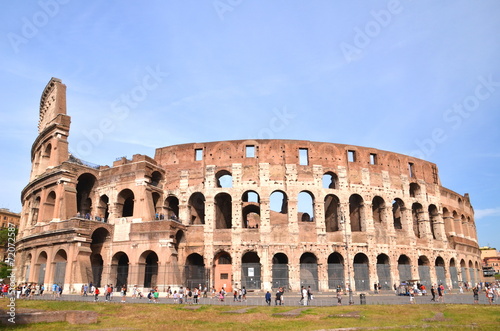 Monumentalne coloseum w Rzymie na tle niebieskiego nieba, Włochy #72072587