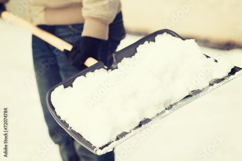 closeup of man shoveling snow from driveway photo