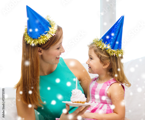 mother and daughter in party hats with cake