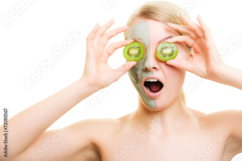 Skin care. Woman in clay mask with kiwi on face