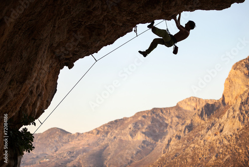 Male rock climber on overhanging cliff at Kalymnos, Greece
