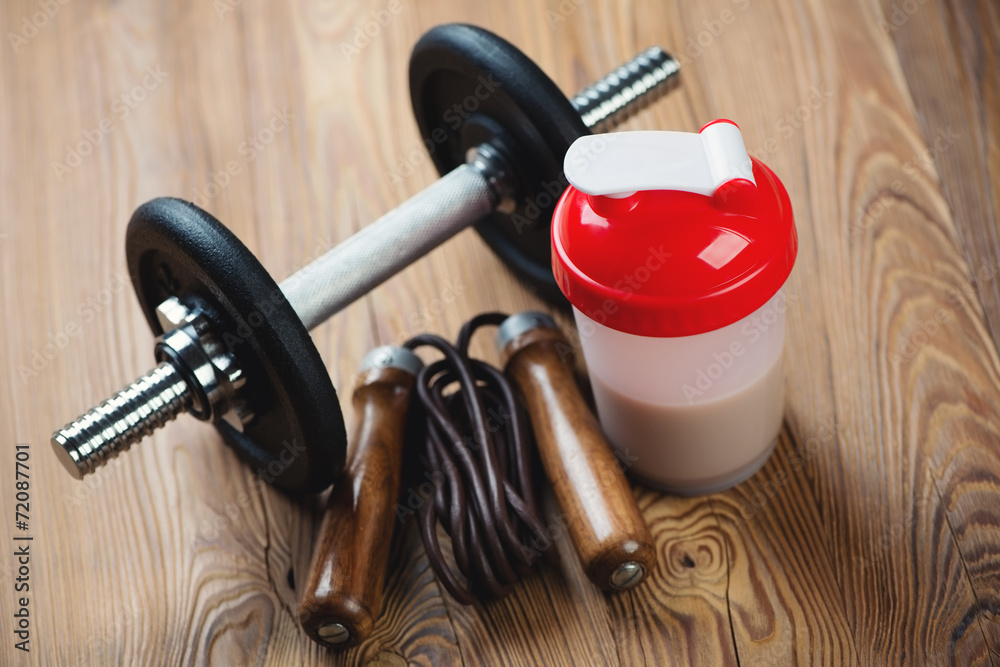Protein shake with a dumbbell and a jumping rope, studio shot StockFoto Adobe Stock