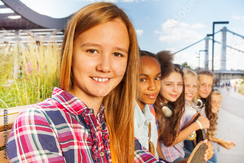 Close up view of girl who sits with other friends