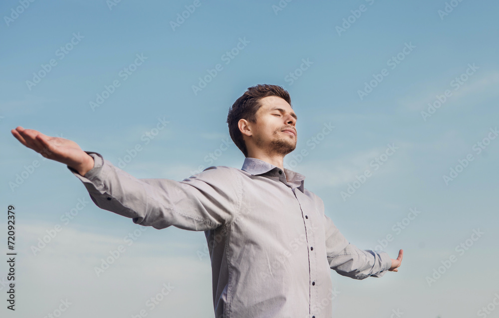 Calm young man portrait over blue sky Calm young man portrait over blue sky