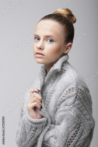 Portrait of Young Pretty Woman in Knitted Woolen Gray Jersey