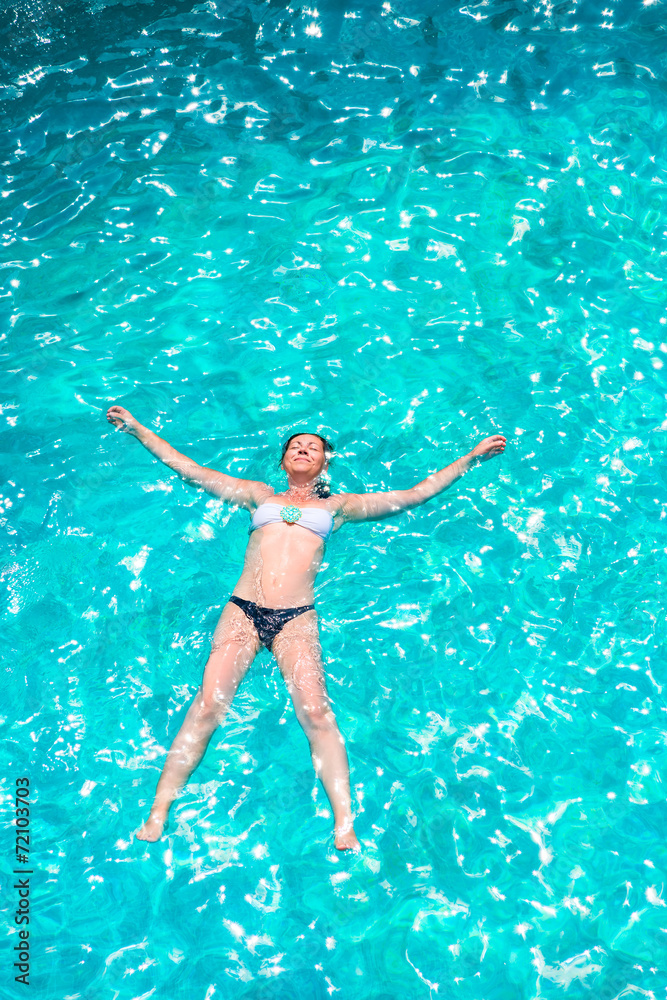 girl in bikini relaxing in the pool in the shape of a star