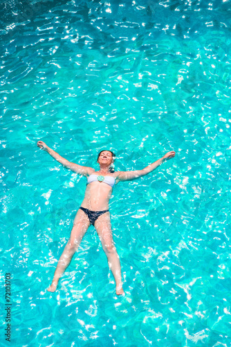 girl in bikini relaxing in the pool in the shape of a star