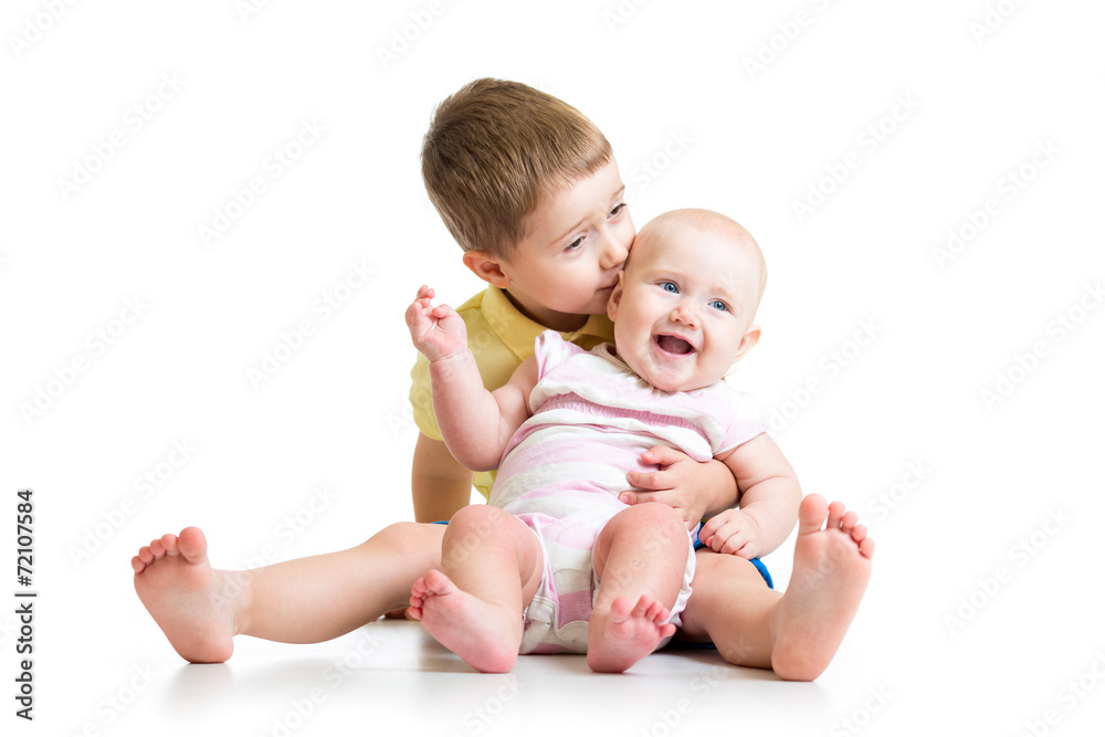 Loving brother kissing baby sister isolated on white Loving brother kissing baby sister isolated on white