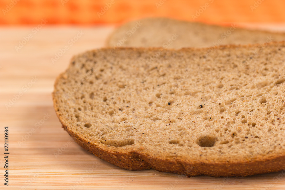 Two slices of rye bread on a wooden table Two slices of rye bread on a wooden table