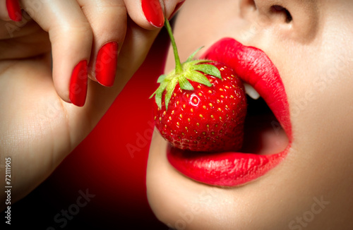 Sexy Woman Eating Strawberry. Sensual Red Lips