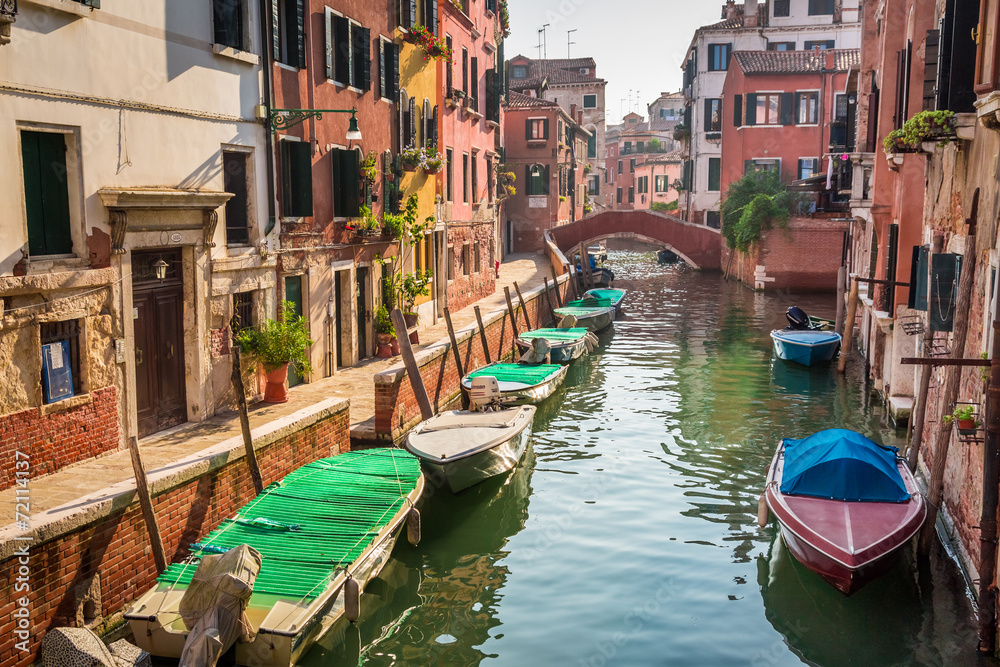 Boats and motorboats on a canal in Venice