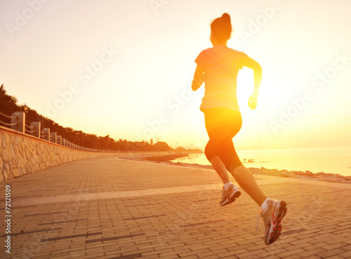 woman runner athlete running at sunrise seaside