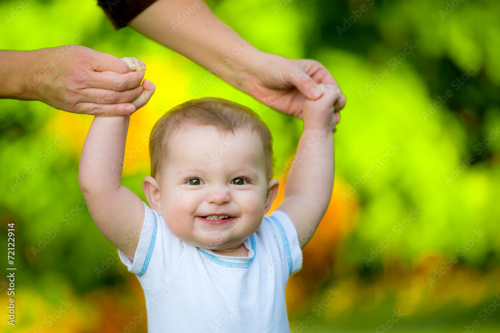 Smiling happy baby learning to walk outdoors Smiling happy baby learning to walk outdoors