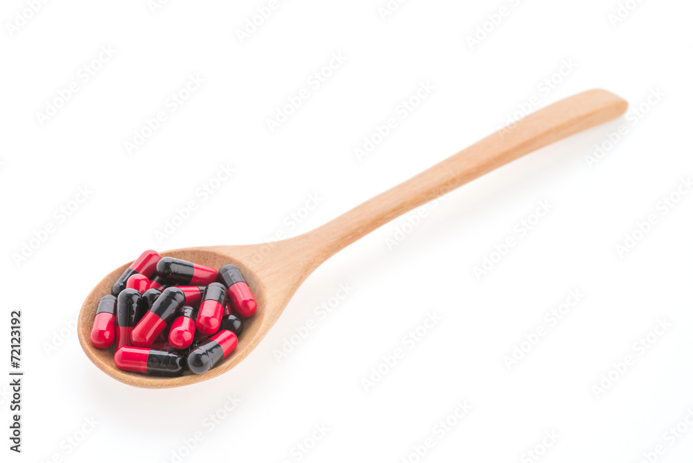 Pills drug on wooden spoon isolated on white background Pills drug on wooden spoon isolated on white background