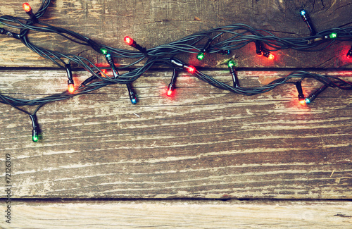 Colorful Christmas lights on wooden  rustic background. filtered