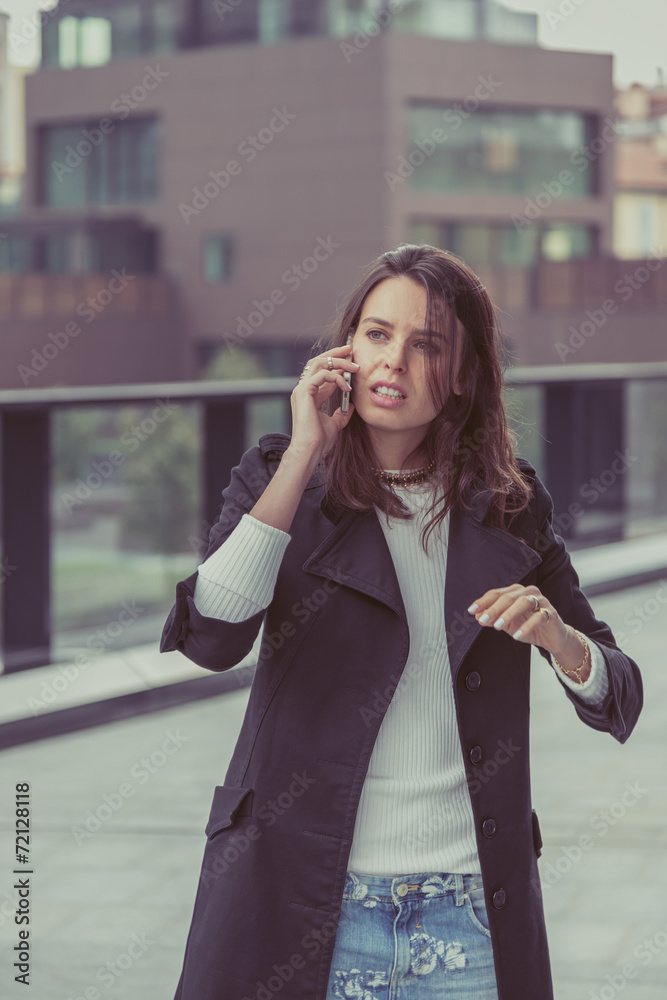 Pretty girl talking on phone in the city streets