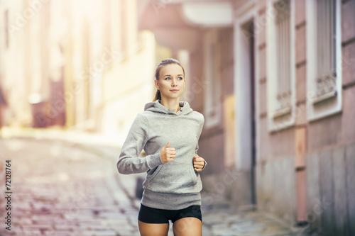 Photography Young woman running in city center