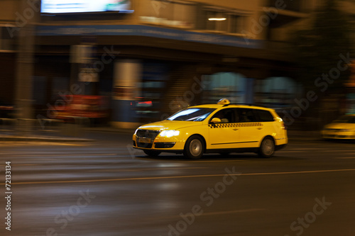 Fototapeta Naklejka Na Ścianę i Meble -  yellow taxi moves on the night city street