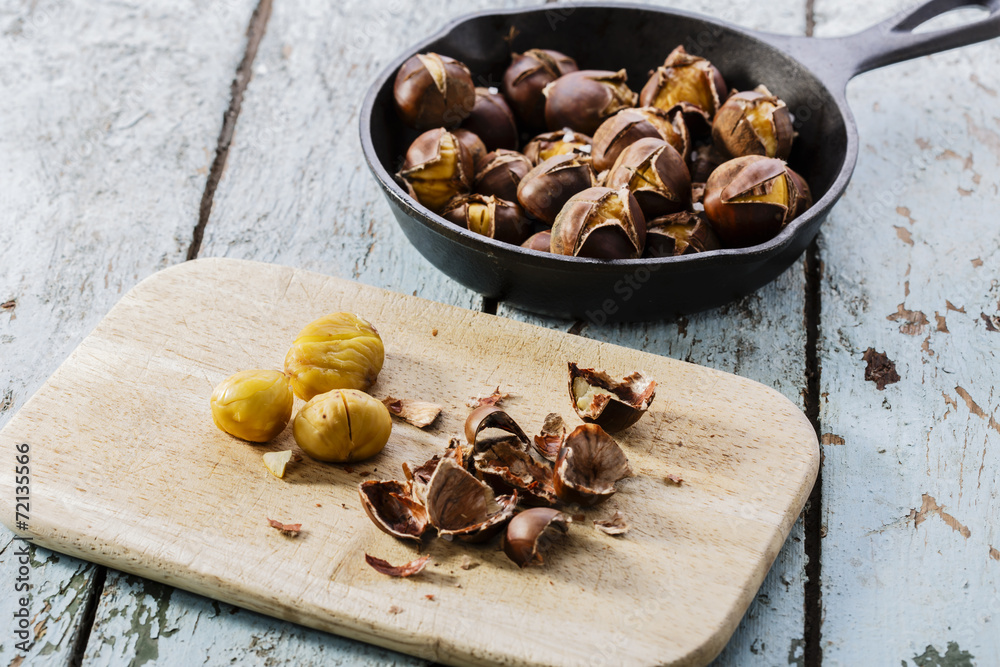Fototapeta premium roasted chestnuts in the pan on a wooden surface