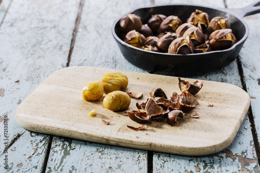 Fototapeta premium roasted chestnuts in the pan on a wooden surface