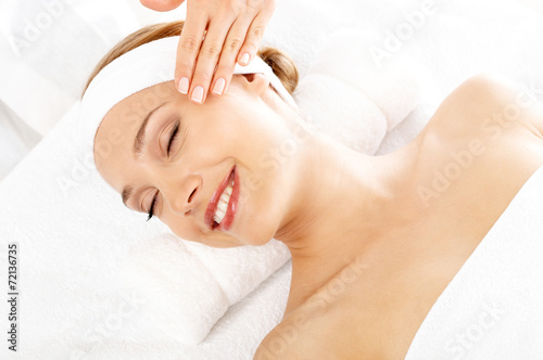 Smiling woman enjoying a facial treatment