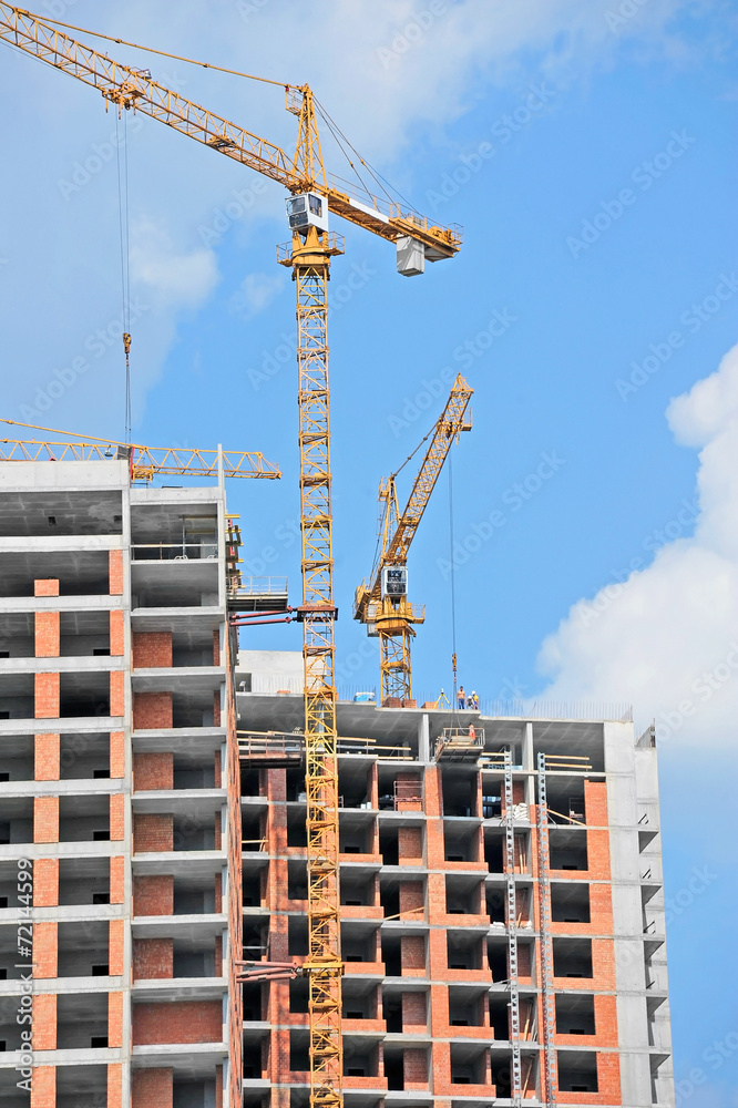 Crane and building construction site against blue sky Crane and building construction site against blue sky
