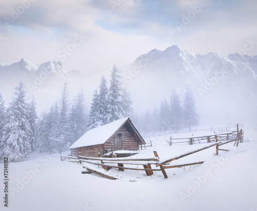 Old farm in the foggy winter mountains
